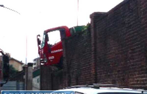 Camion dei rifiuti si schianta e resta in bilico su un muro