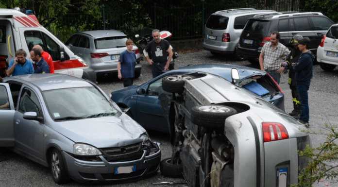 Parcheggia male e piomba sulle auto sottostanti ribaltandosi