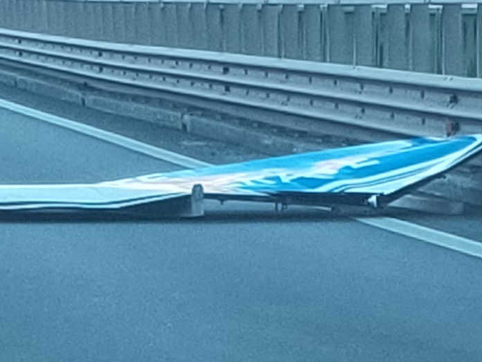 Il cartello caduto sul Terzo Ponte lungo la SS36 in direzione Nord (foto Facebook)
